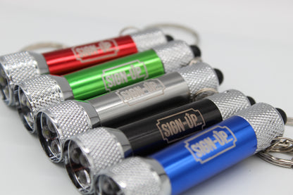 Set of small flashlights with keychains on a white background