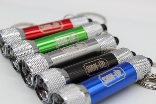 Set of small flashlights with keychains on a white background